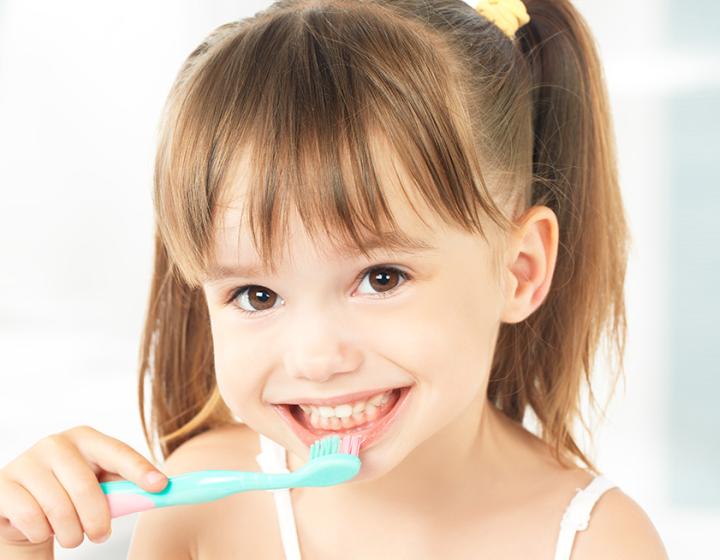 Pieni tyttö harjaa hampaita