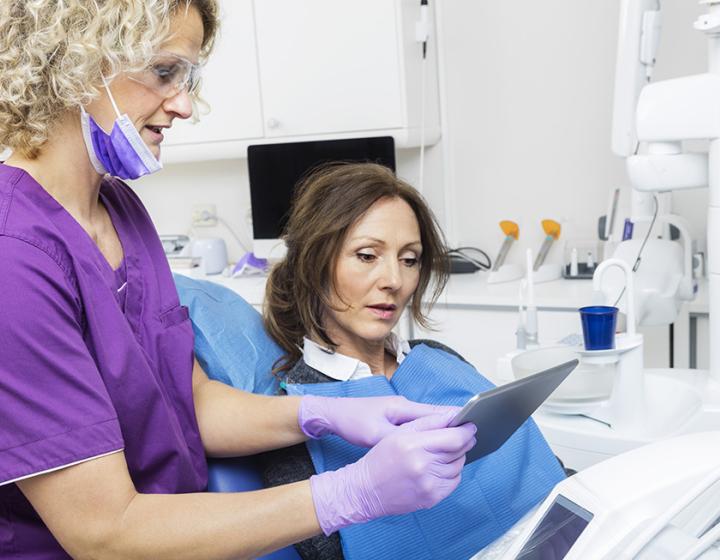 hammaslääkäri antaa vastaanotolla potilaalle ohjeita omahoitoon